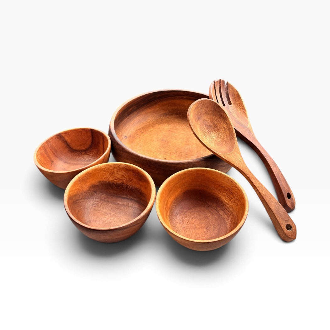 A set of handcrafted wooden tableware including four bowls and two serving utensils (spoon and fork) in a warm medium brown wood tone, arranged on a clean white background.