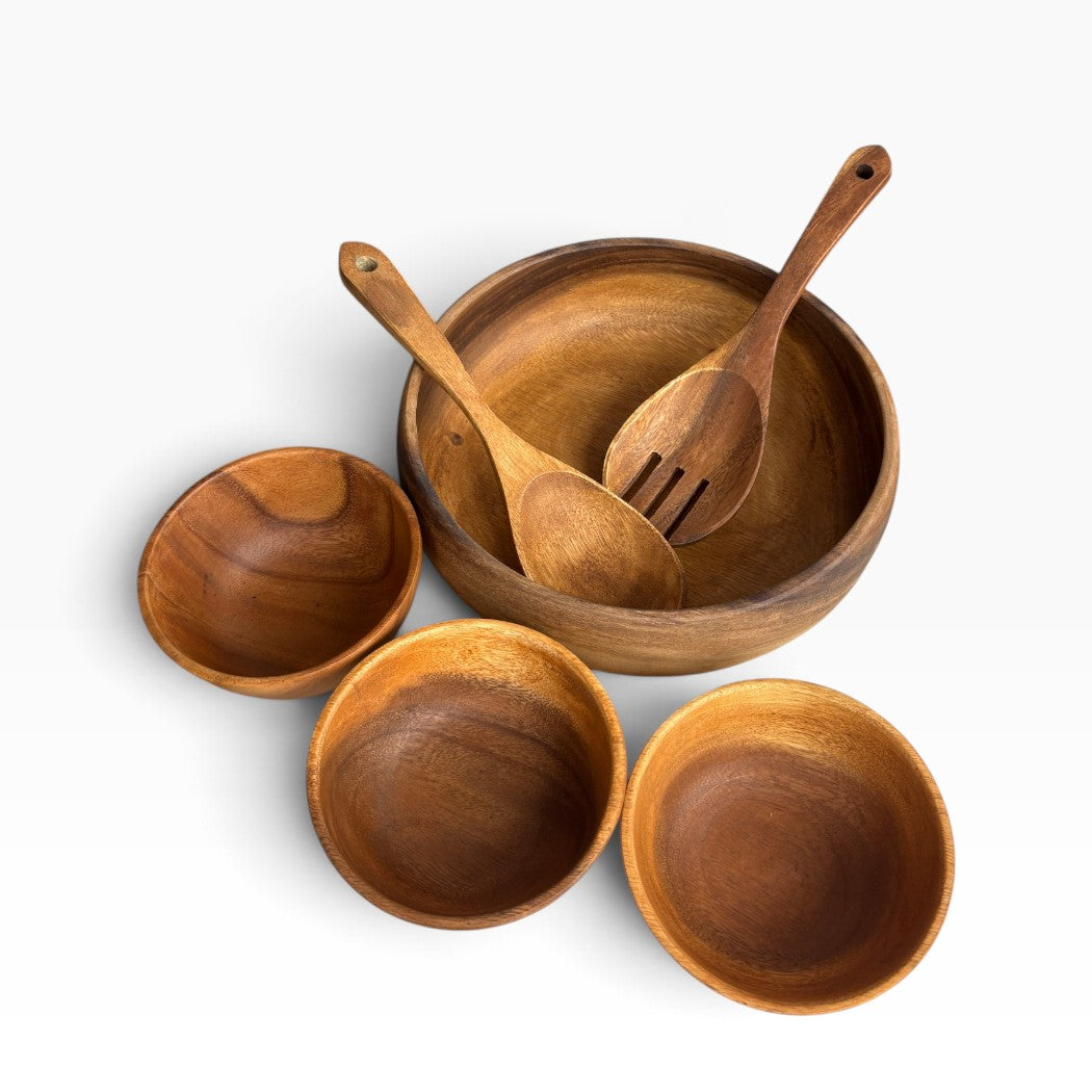 A set of wooden dining tableware including a large mixing bowl with two utensils and three smaller serving bowls, photographed on a clean white background.