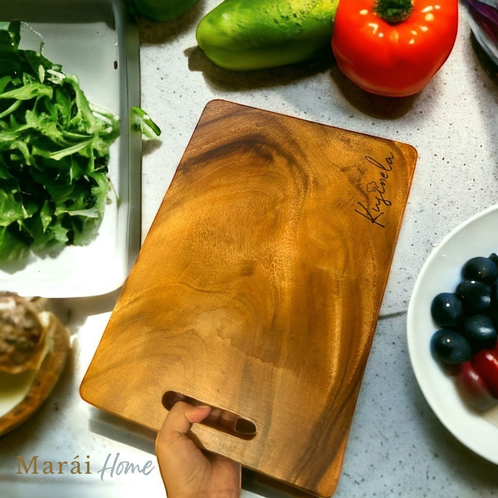 Marai Home acacia wood chopping board with engraved name, featuring a handle slot. Perfect for prep or serving.