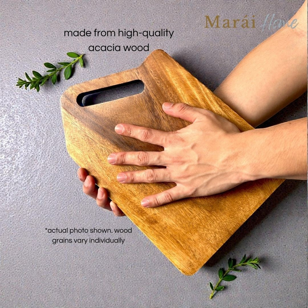 Marai Home acacia wood cutting and serving board with a cutout handle and natural wood grain.