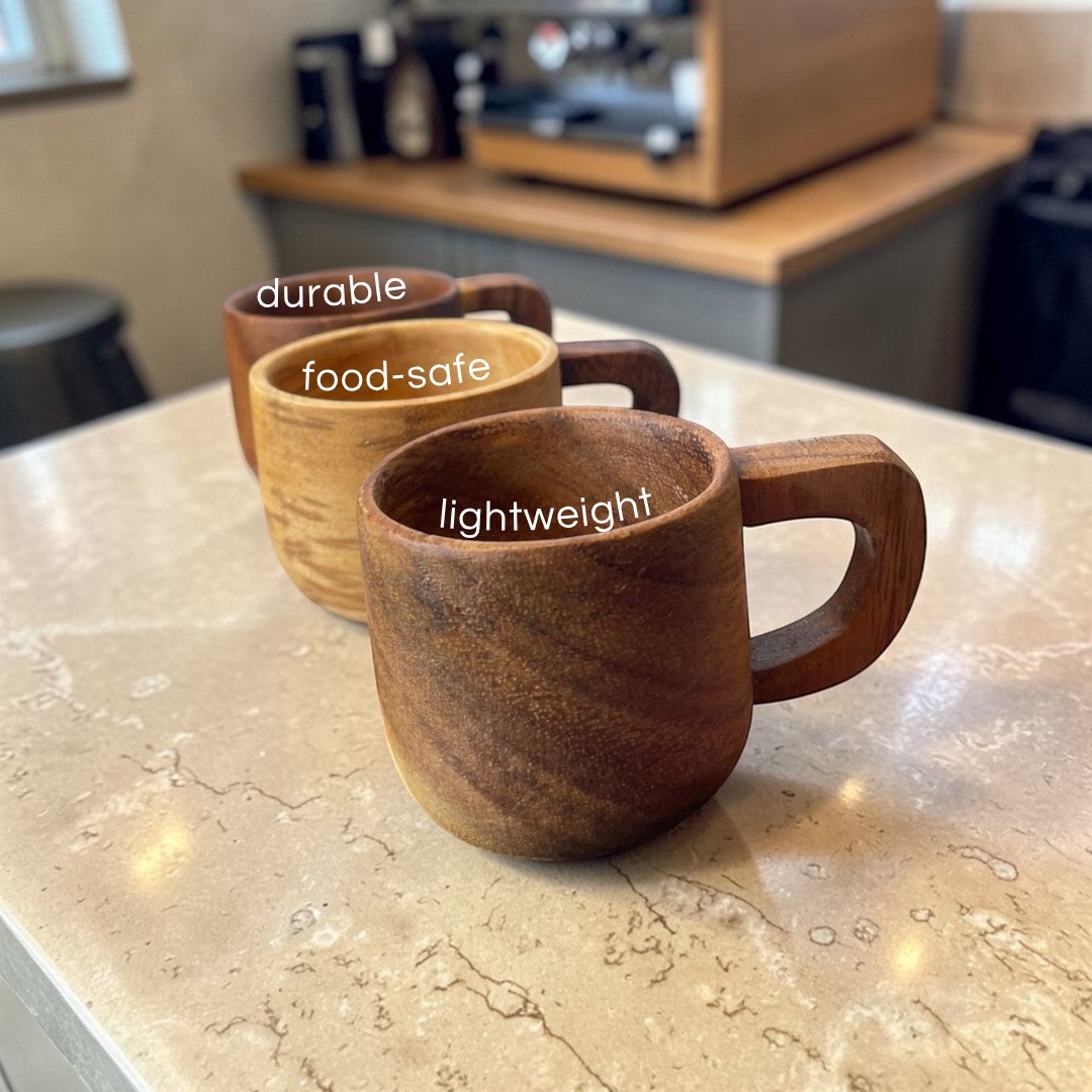 Marai Home three small acacia wood espresso cups with handles, showing natural wood grain and varying shades of brown.