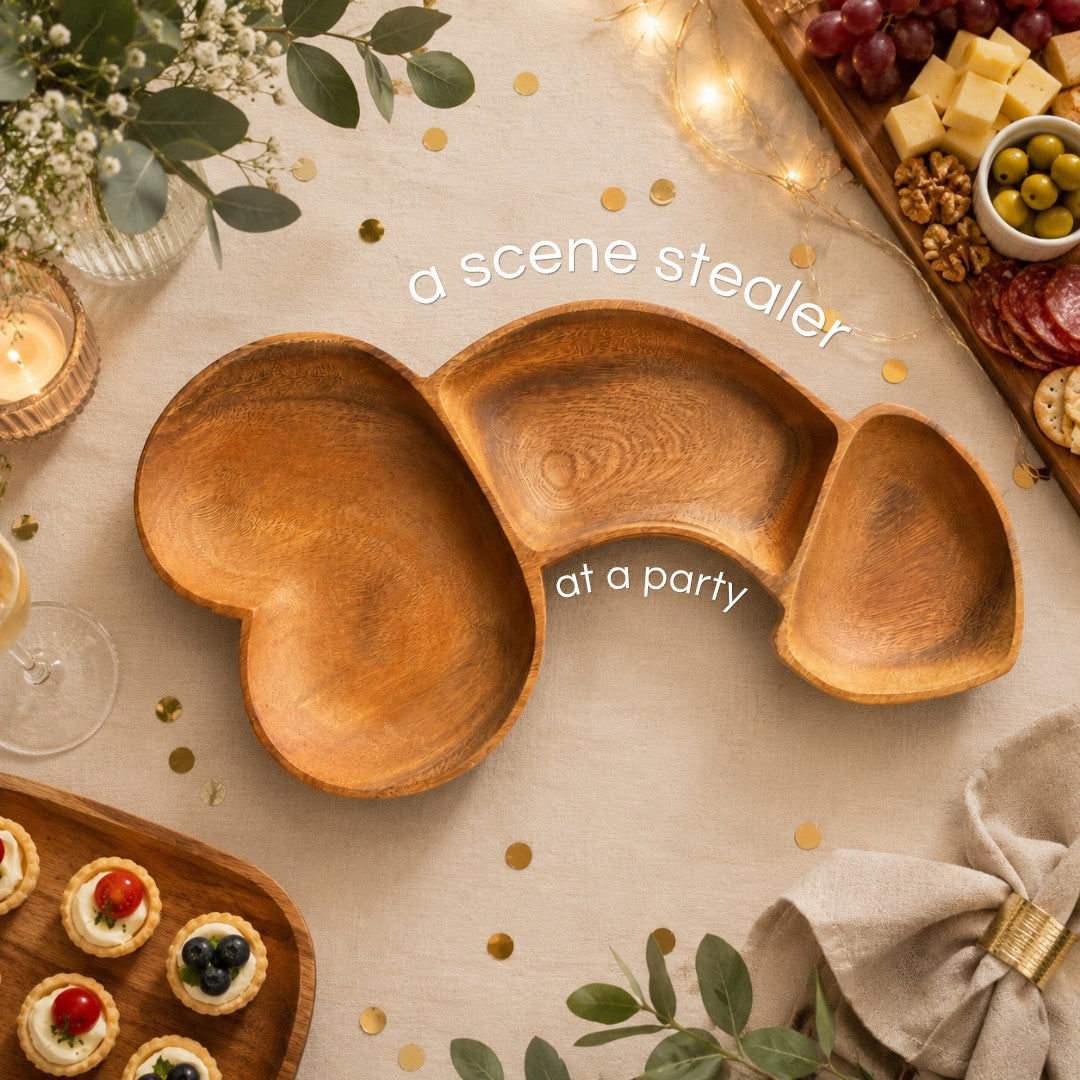 Marai Home Party Starter naughty-shaped acacia wood charcuterie board on a festive table with snacks.