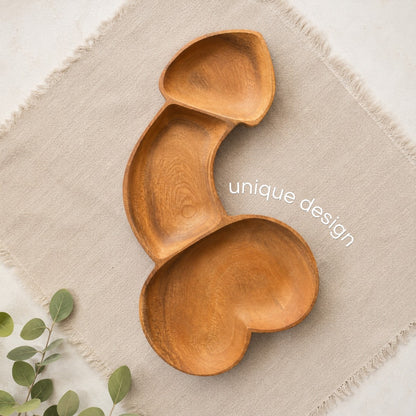 Marai Home naughty acacia wood charcuterie board with a unique phallic shape on a beige linen napkin
